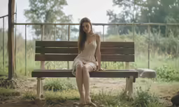 a woman sitting on top of a bench in a park