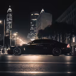 a black car driving down a street next to tall buildings