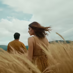 two people standing together in a field of tall grass