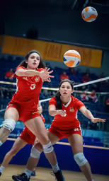 two women playing a game of volleyball in a stadium