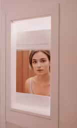 a woman that is looking through a mirror