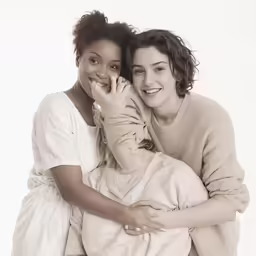 two young women hugging each other and smiling