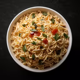 this is a bowl of pasta and basil on a black table