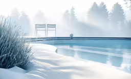a pool sits next to two chairs on a snow covered hill