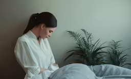 a woman sitting on a bed looking at something