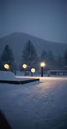 snow covered ground with lights and a bench