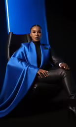 woman sitting in a leather chair wearing blue jacket