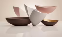 three small bowl that are all different colors and shapes