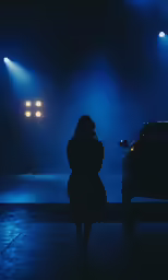 a woman in a dress stands on a wooden bench near cars
