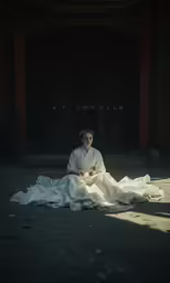 a woman in a white outfit sitting on the ground