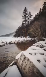 a snow covered river near a forest with trees
