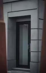 a modern looking building with a gray door and glass