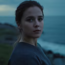 a woman is by the water looking at something