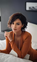 a woman poses on the bed in a dress