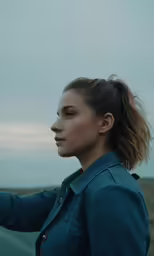 a girl stands next to an overcast sky