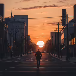 a person walking down a street under an orange sun