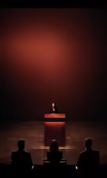 an audience watches as a speaker stands behind a podium