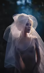 a nude bride in a veil standing naked