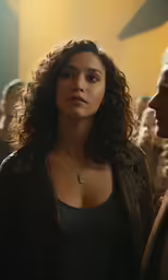 a woman wearing a black top standing in front of other people