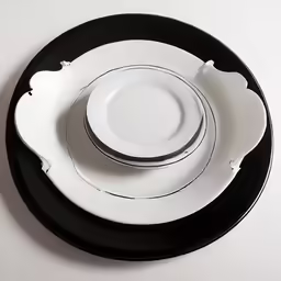 an assortment of black and white dinnerware with black accents