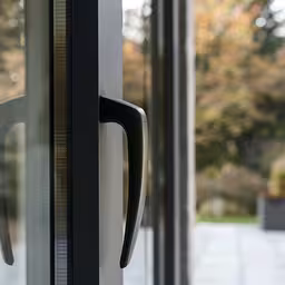 the door handles to a door and some windows,a close up of a metal door handle on a glass door