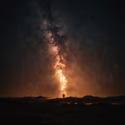 fireworks that are glowing in the sky near some buildings