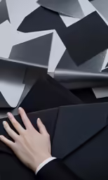 an open hand in an open space between several pieces of black and grey material