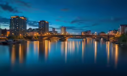 lights on the bridge and buildings reflected in the water