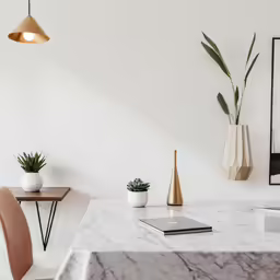a modern kitchen with white walls and marble countertop