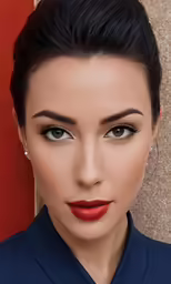 the woman with black hair and orange lipstick is looking straight ahead
