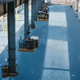 a blue floor with hanging chairs and a desk in it