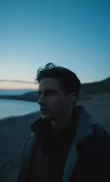 the man is walking along the sand near the water