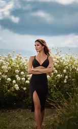 a woman standing in front of flowers and white flowers