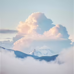 a mountain range with many clouds in the foreground