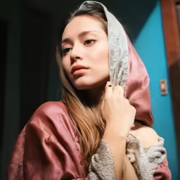 a woman with a hooded jacket is posing