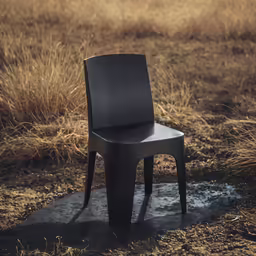 a dark chair is placed in a field