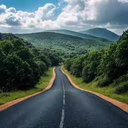 the view from the top of an empty road in the mountains