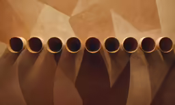 six large ceramic vases on a tan wall
