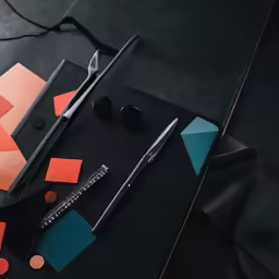 a pair of scissors sits next to some sort of material