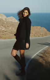 a woman in short dress standing on the side of the road