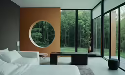 a minimal bedroom with a large round window in the corner