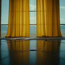 a window with a yellow curtain and water drops on the floor