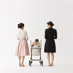 three women in vintage dress look at the back of a stroller