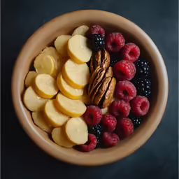 a bowl of fruit, nuts and raspberries