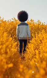 the woman is standing in the field near some trees