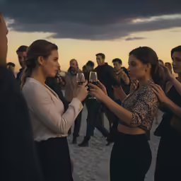 two women giving each other a glass of wine