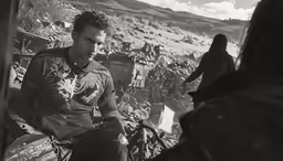 a man with a tattoo sitting on a bench