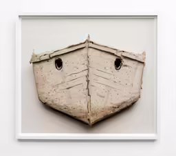 a boat is sitting in a frame on a wall