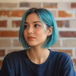 a young girl with dyed blue hair looks away from the camera