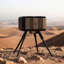 a camera on the ground with a desert landscape in the background